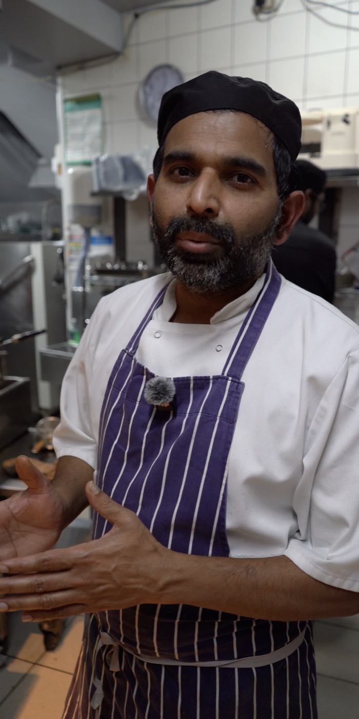 The head chef at Madras Eatery talking to camera in the kitchen