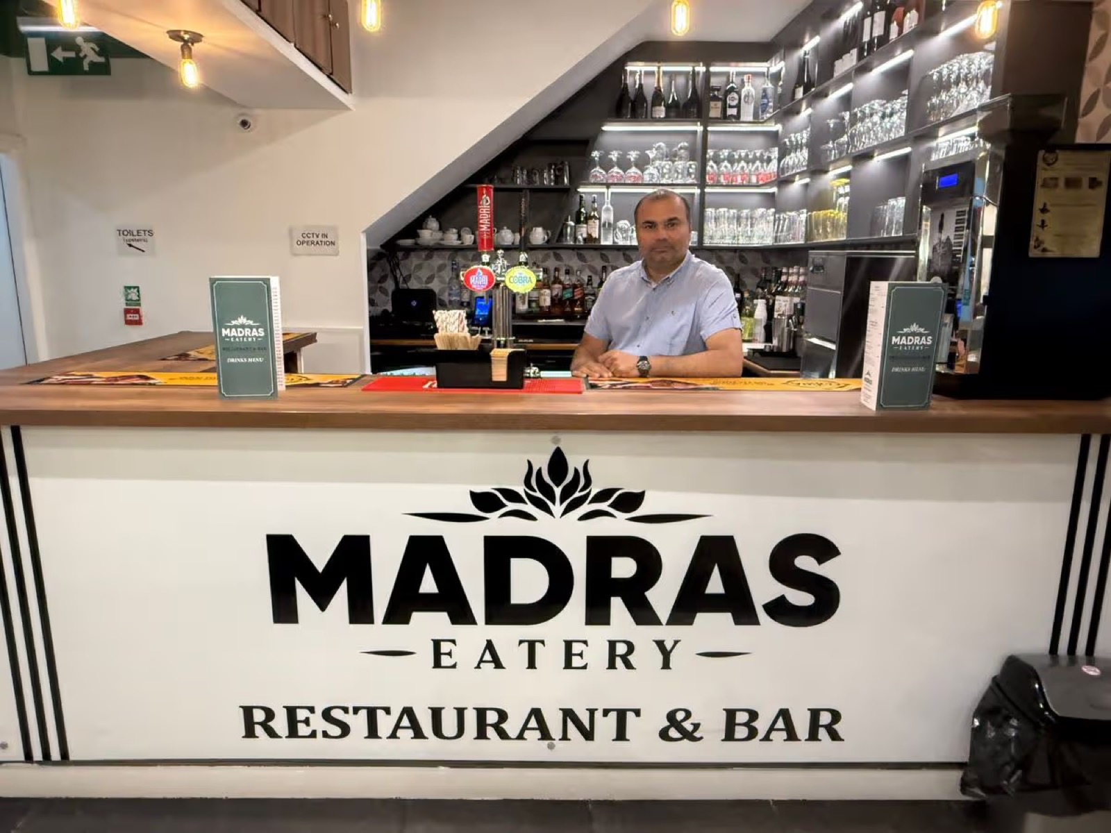The owner of Madras Eatery behind the bar at his Birmingham restaurant